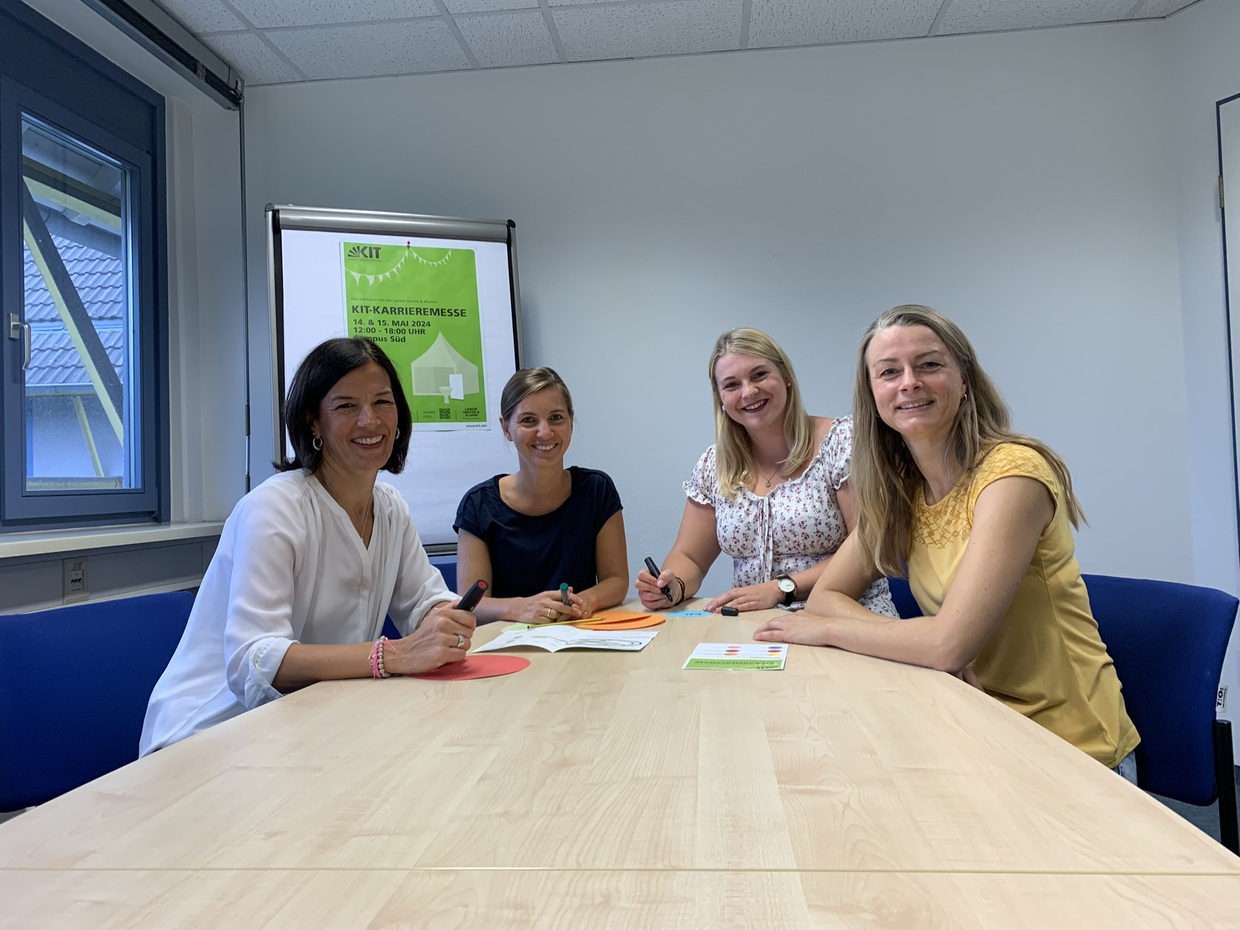 Bild vom Messeteam am Tisch sitzend, von links nach rechts, Christine Schehl, Jette Leonhardt, Steanie Valter und Sarah Schramm